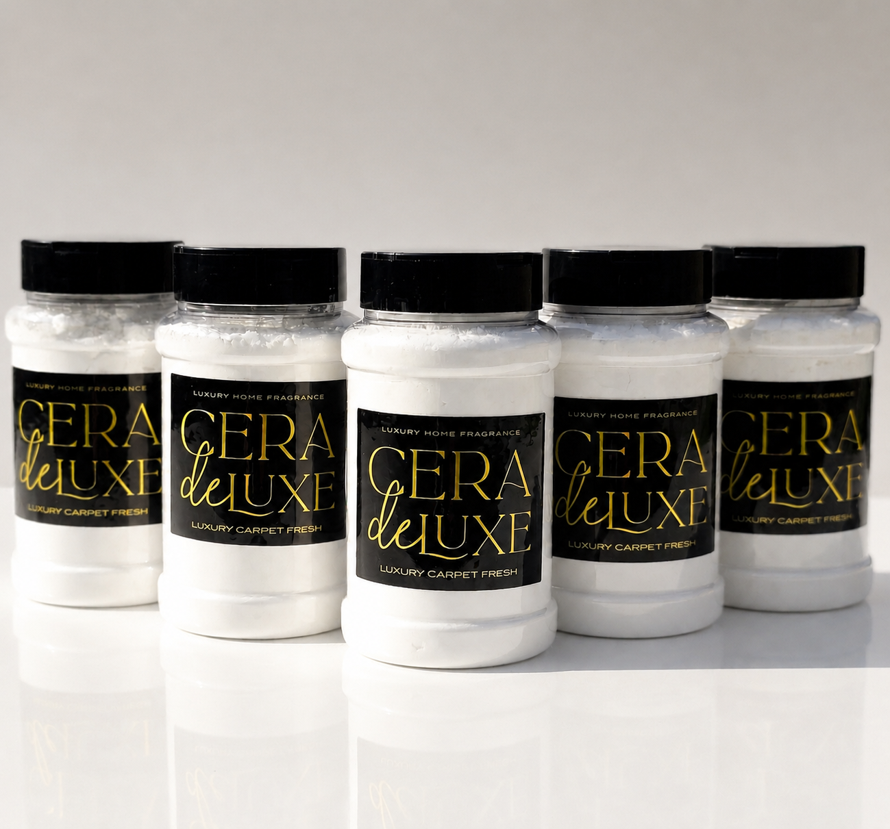 Five jars of Cera De Luxe carpet freshener on a white background